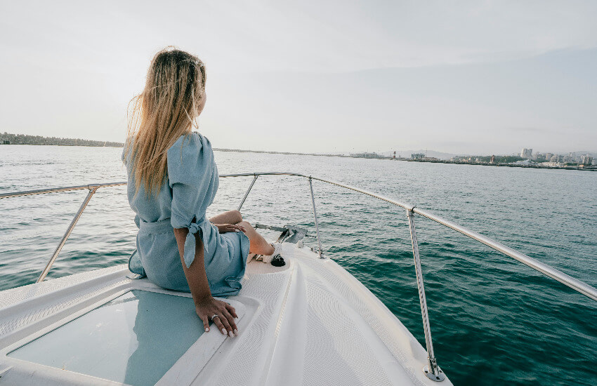 Eine Frau sitzt auf einer Yacht und genießt die Aussicht auf das Meer.